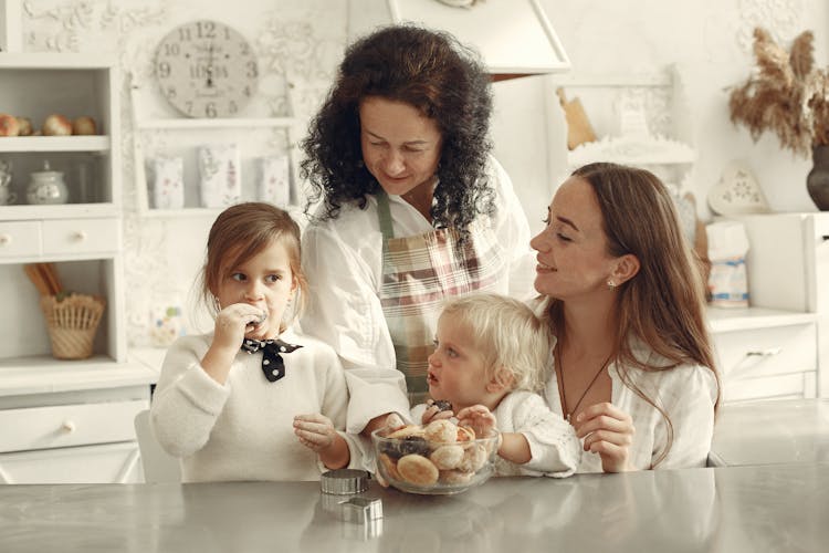 Family Eating Cookies While In The Kitchen