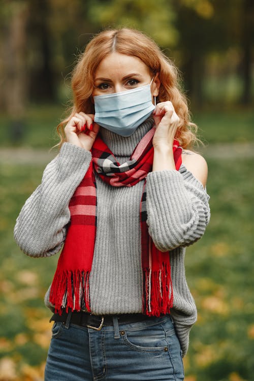 Free Woman in Gray Knit Sweater Covering Face With White Face Mask Stock Photo