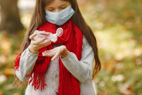 Girl Wearing A Scarf Pouring Sanitizer On Hand