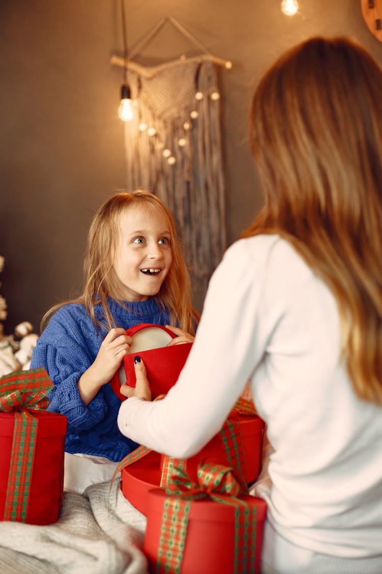 Daughter Opening Christmas Gift From Mother