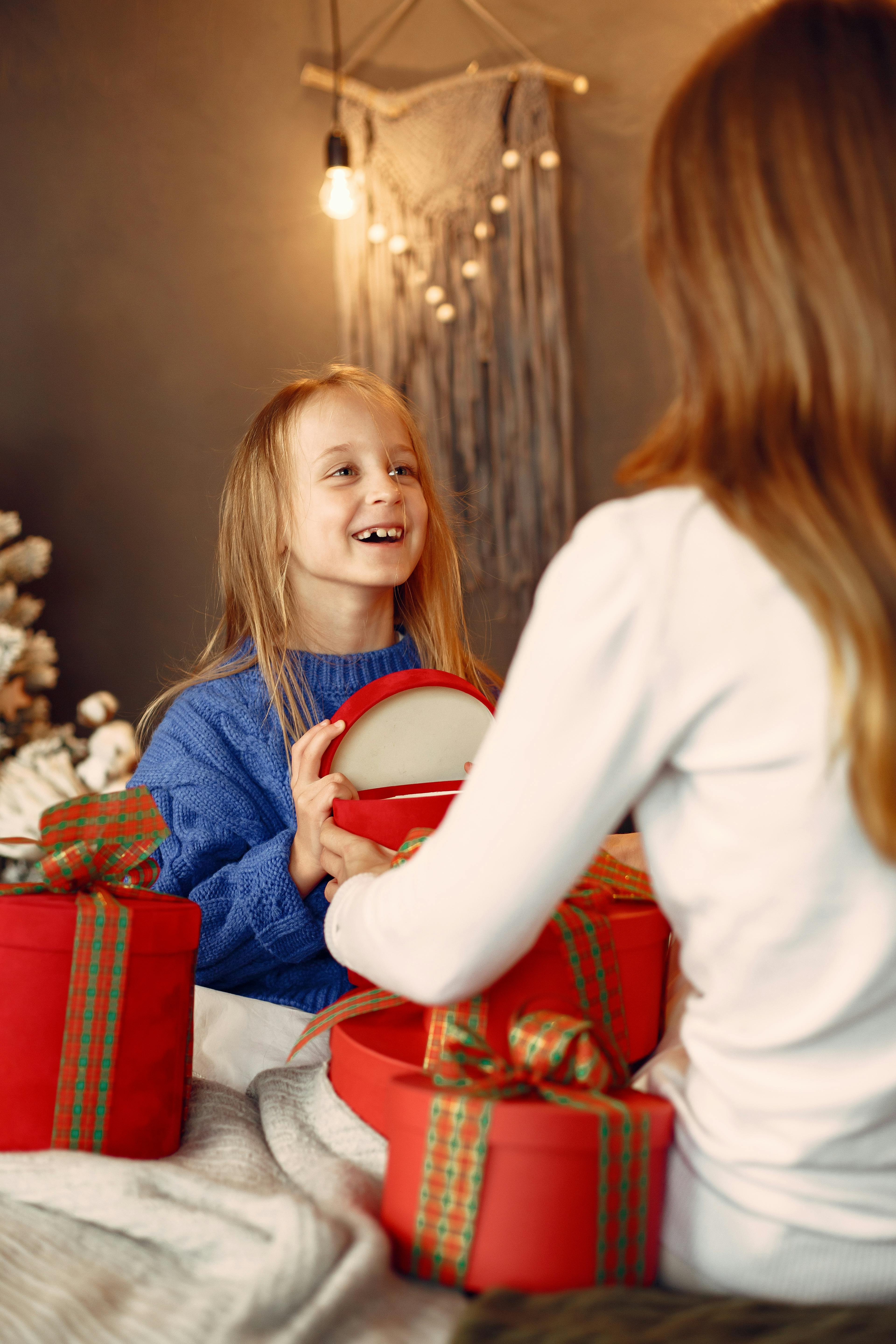 happy girl unpacking presents with mother