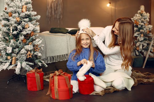 Free Mother and Daughter Sitting next to Christmas Presents on the Floor Stock Photo
