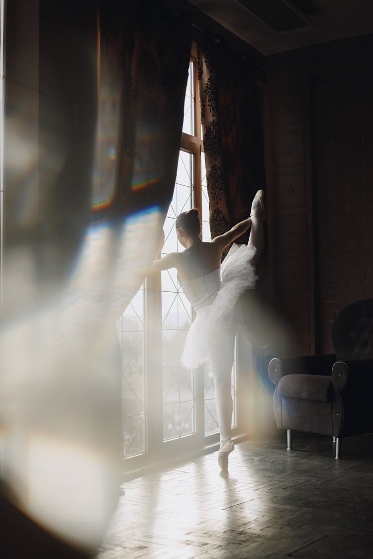 Ballerina In Tutu Dress Dancing Near The Window