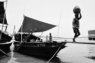 Man in Black Jacket and Pants Standing on Boat in Grayscale Photography