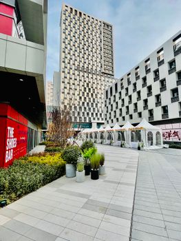 A contemporary urban plaza with skyscrapers and white event tents, showcasing modern architecture.
