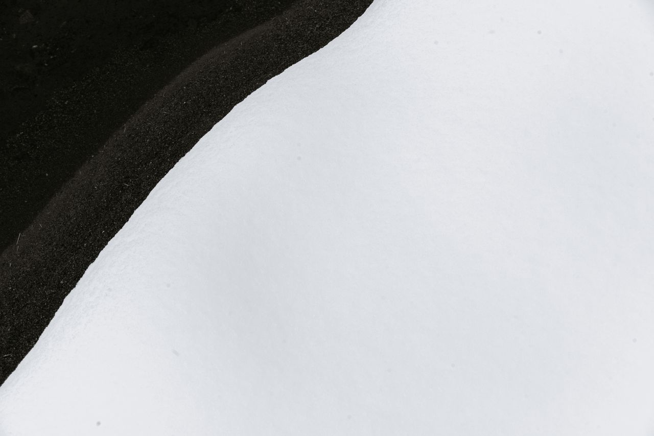 top view of calm river flowing near bank covered with soft white snow