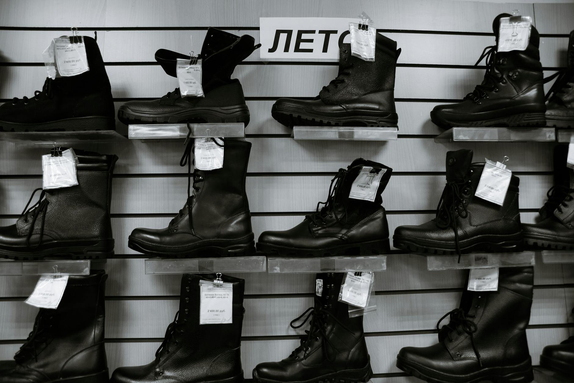 Black and white high leather boots with laces placed on shelves in shop