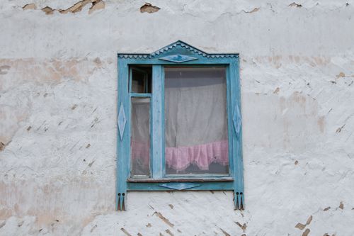 Free Low angle of aged blue wooden window on shabby house with cracked walls located in countryside in daytime Stock Photo