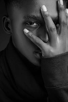 Expressive portrait of a young man in black and white with a contemplative gaze.