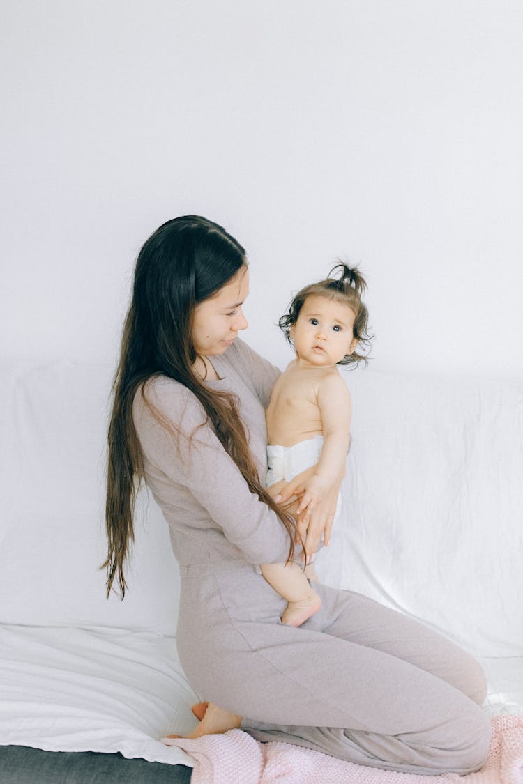 Woman In A Dress Holding A Baby