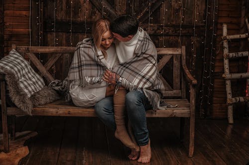 Loving couple hugging on wooden bench at home