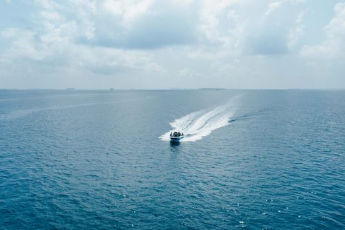 Free Modern motorboat floating fast on vast rippling sea under blue sky on clear sunny weather Stock Photo