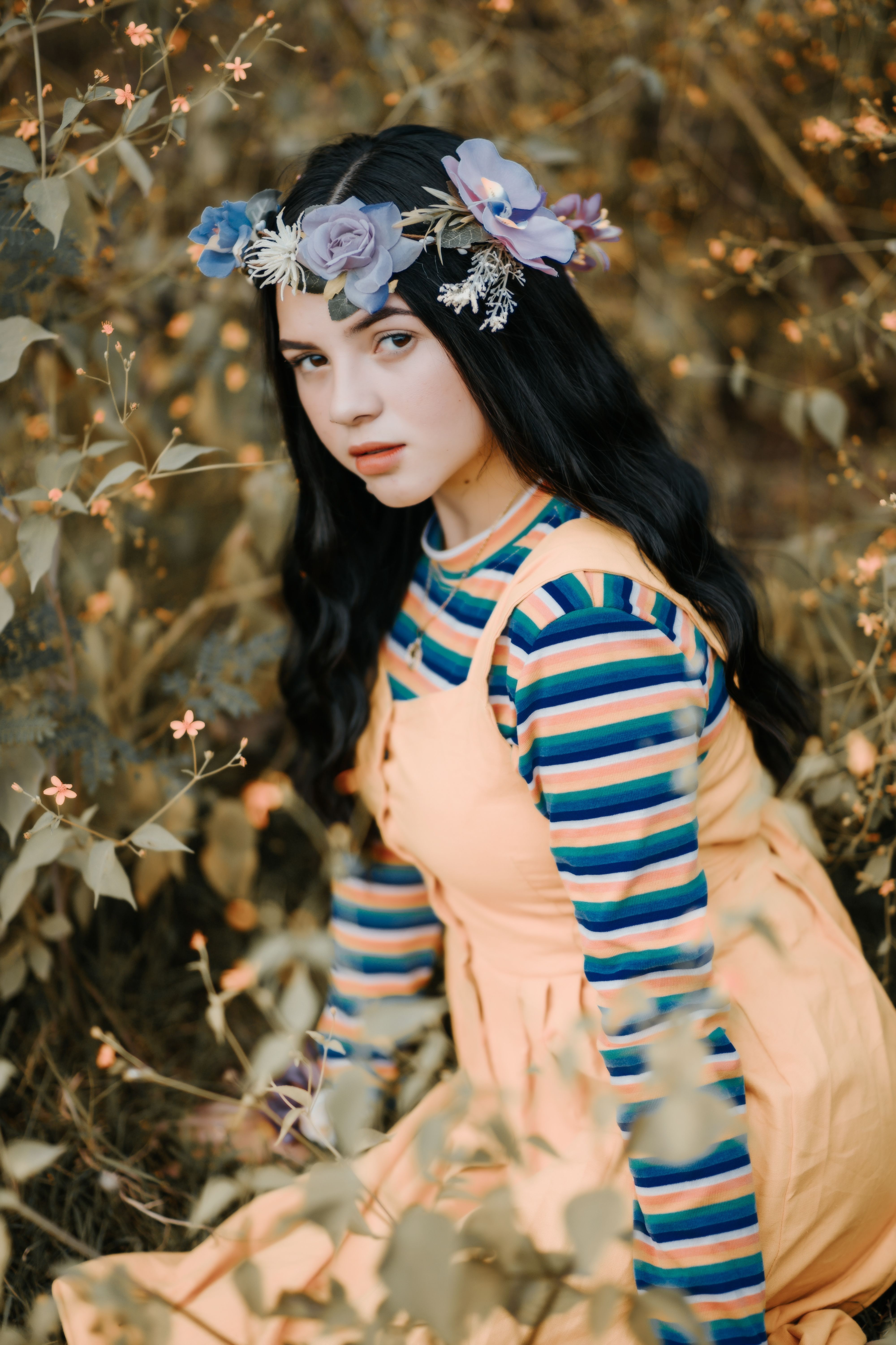 这是一幅时尚肖像，画中一位头戴花卉王冠的女子，四周环绕着大自然的鲜花
