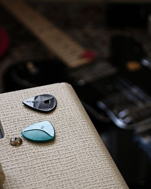 Free Artistic close-up of two guitar picks on top of an amplifier with a blurred background. Stock Photo