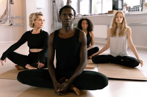 Free Mixed group of adults meditating in a serene yoga class environment. Stock Photo
