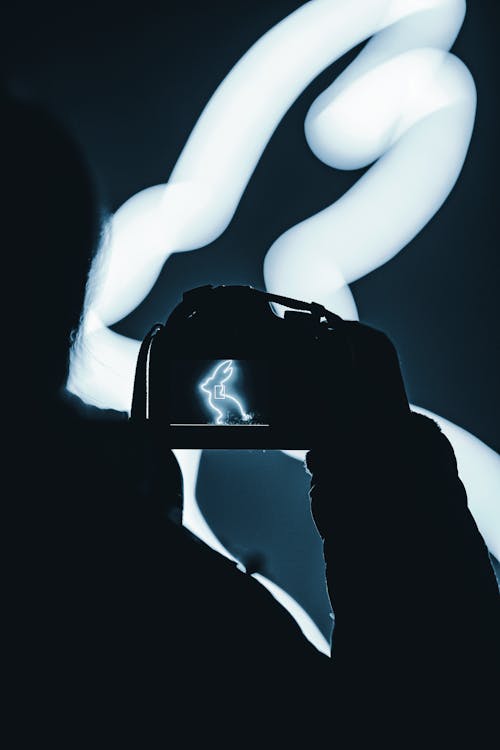 Silhouette Of A Person Holding A Camera