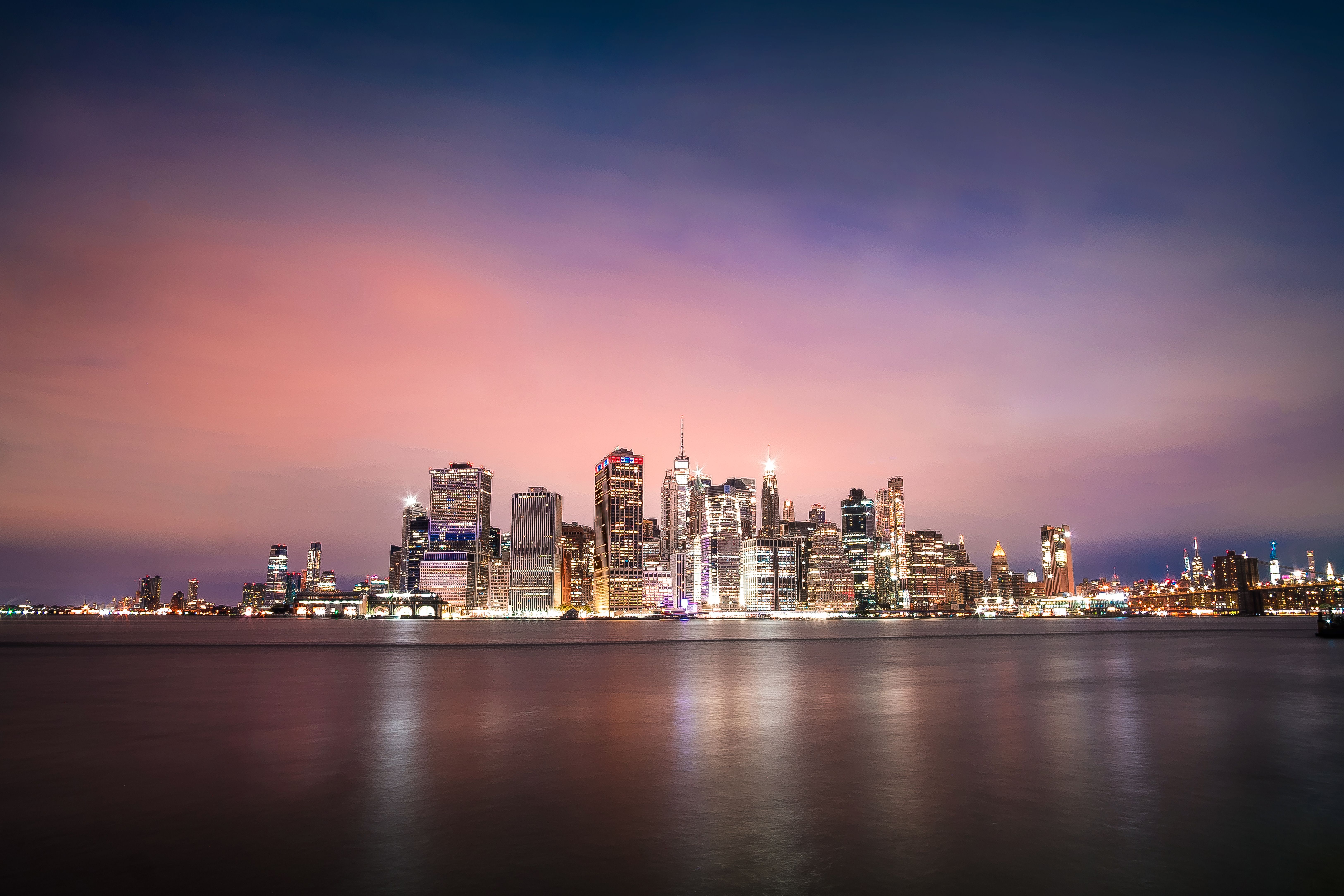 现代大都市海滨夜间发光的摩天大楼壮丽远景