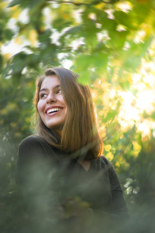 Free Smiling female standing in green park Stock Photo