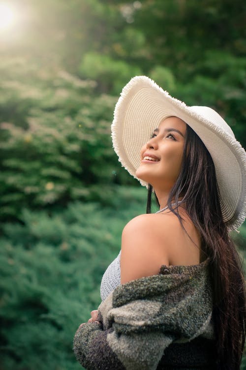 Charming model in stylish clothes against green trees