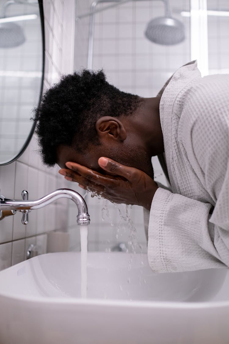 Man Washing His Face In The Bathroom