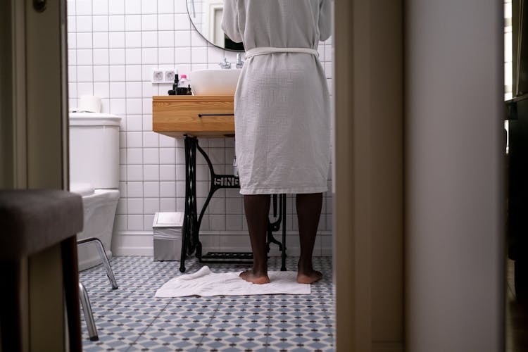 Woman In Bathrobe Standing In Bathroom