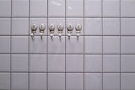 Close-up of Towel Hangers with Letters Attached to the Tiles in a Bathroom