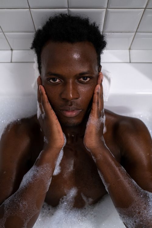Free A man enjoying a relaxing bath with bubbles, conveying a sense of calm and hygiene. Stock Photo