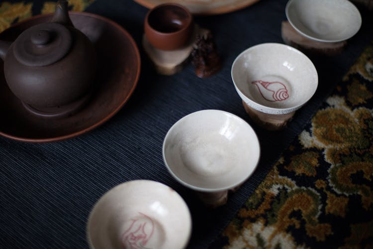 Cup And Teapot Placed On Carpet During Traditional Asian Tea Ceremony