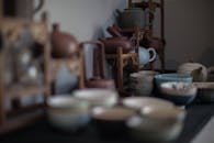 Ceramic cups and teapots placed on table in daylight