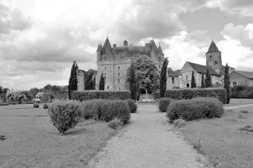 Grayscale Photo of Castle Under White Clouds
