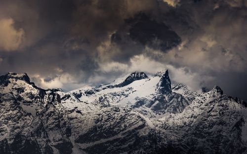 Free Atmospheric view of snow-covered mountains under a cloudy sky in Lombardy, Italy. Stock Photo