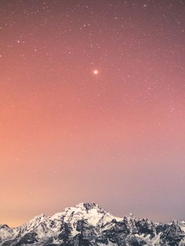 白雪覆盖的山峰上，迷人的星空营造出宁静的冬季氛围