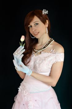 一位身着优雅连衣裙、戴着镶珠手套的年轻女性，在黑色背景下露出微笑，注视着镜头