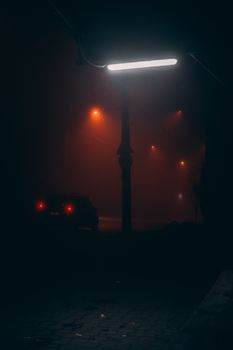 夜间雾霾中汽车尾灯与城市手电筒的剪影