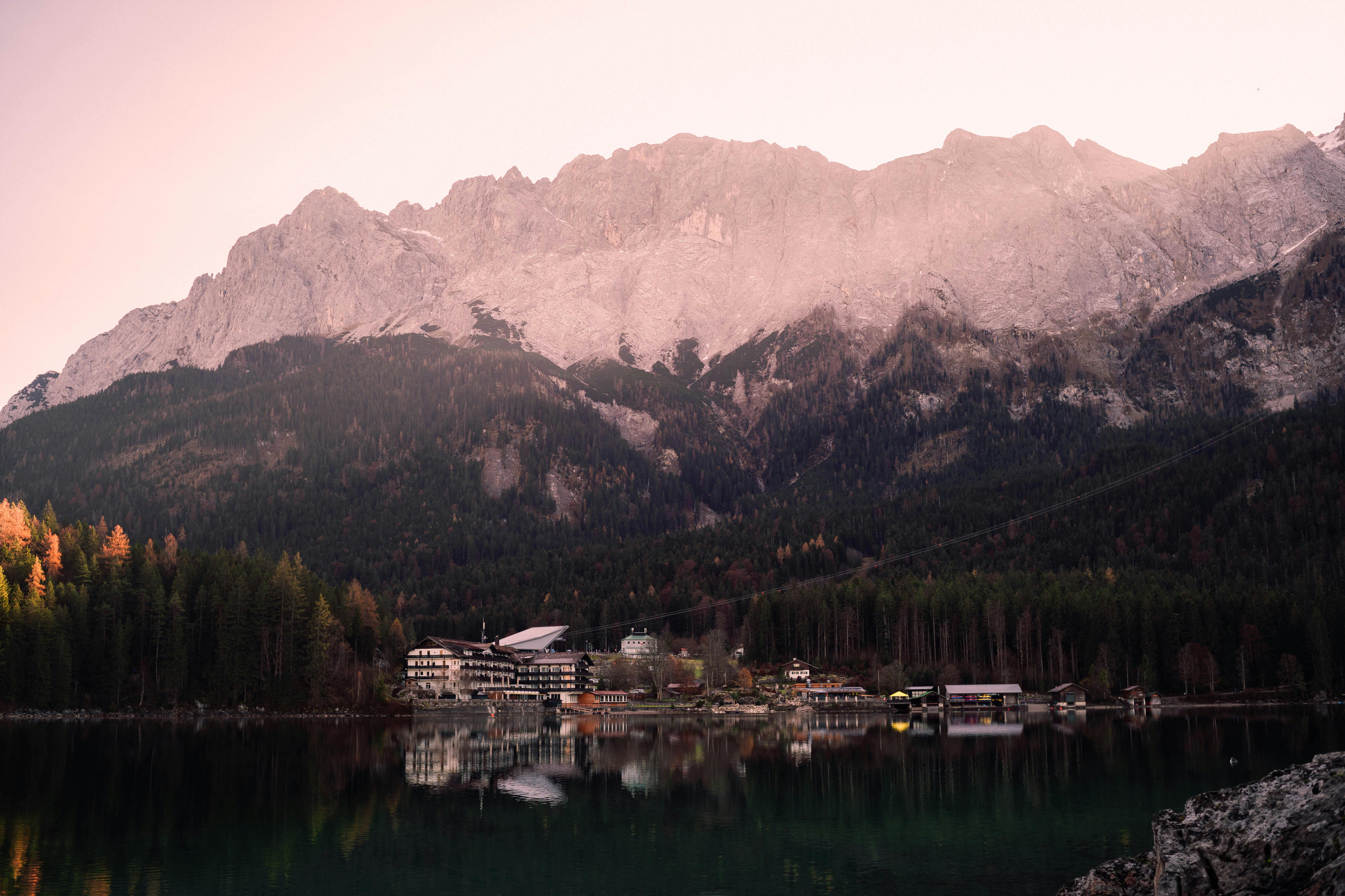 Tranquil lake reflects lush forest and stunning mountain at twilight.