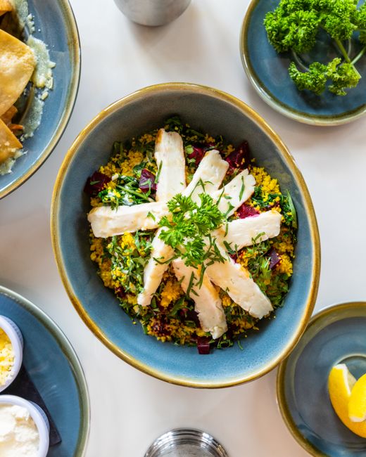 Delicious quinoa salad topped with cheese slices and fresh herbs, perfect for a nutritious meal.