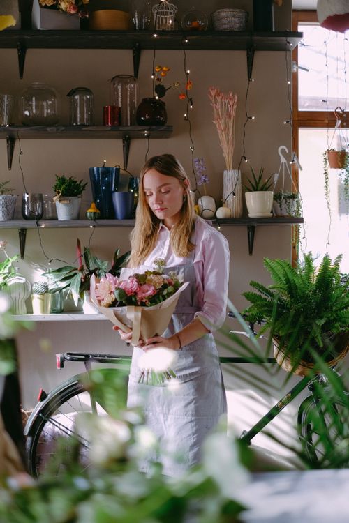 Free A florist arranges a colorful bouquet in a cozy indoor plant shop. Stock Photo