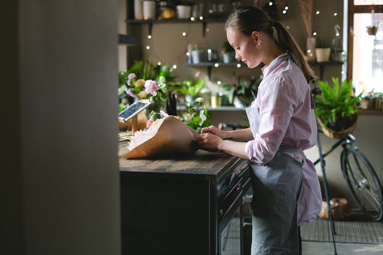 Woman In Pink Long Sleeve Shirt Arranging Flowers