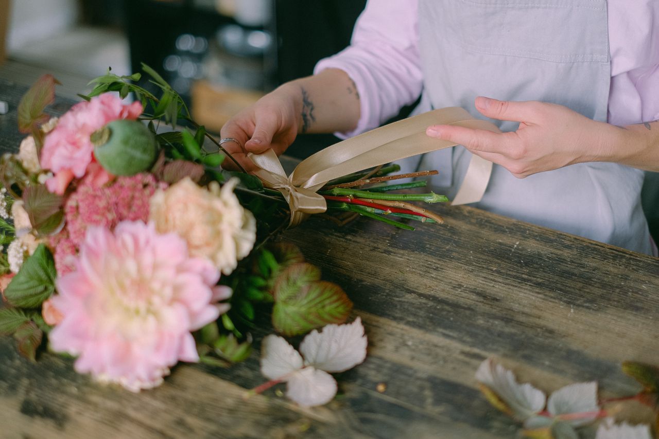 florist arranging a beautiful floral bouquet with delicate hands and s