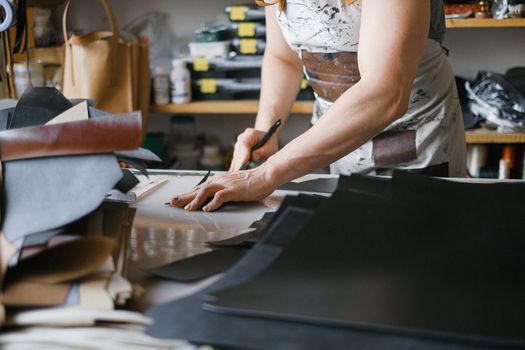 A person skillfully cuts fabric in a workshop, showcasing craftsmanship and creativity.