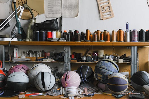 A creative workshop with basketball-themed handbags beside sewing tools and threads.