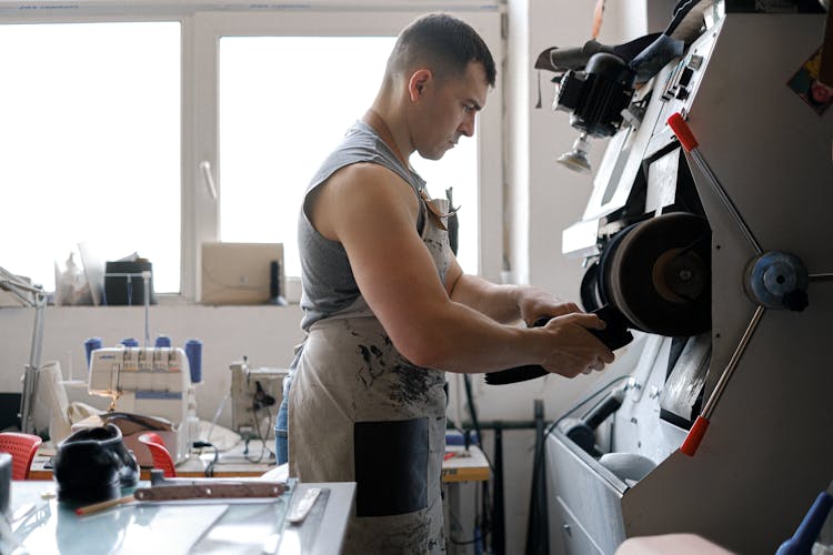 A Man Sanding The Leather Shoes