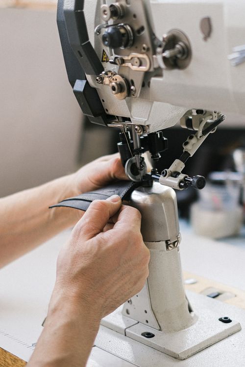 Free Close-up shot of hands crafting leather on a sewing machine, showcasing artisanal skills. Stock Photo