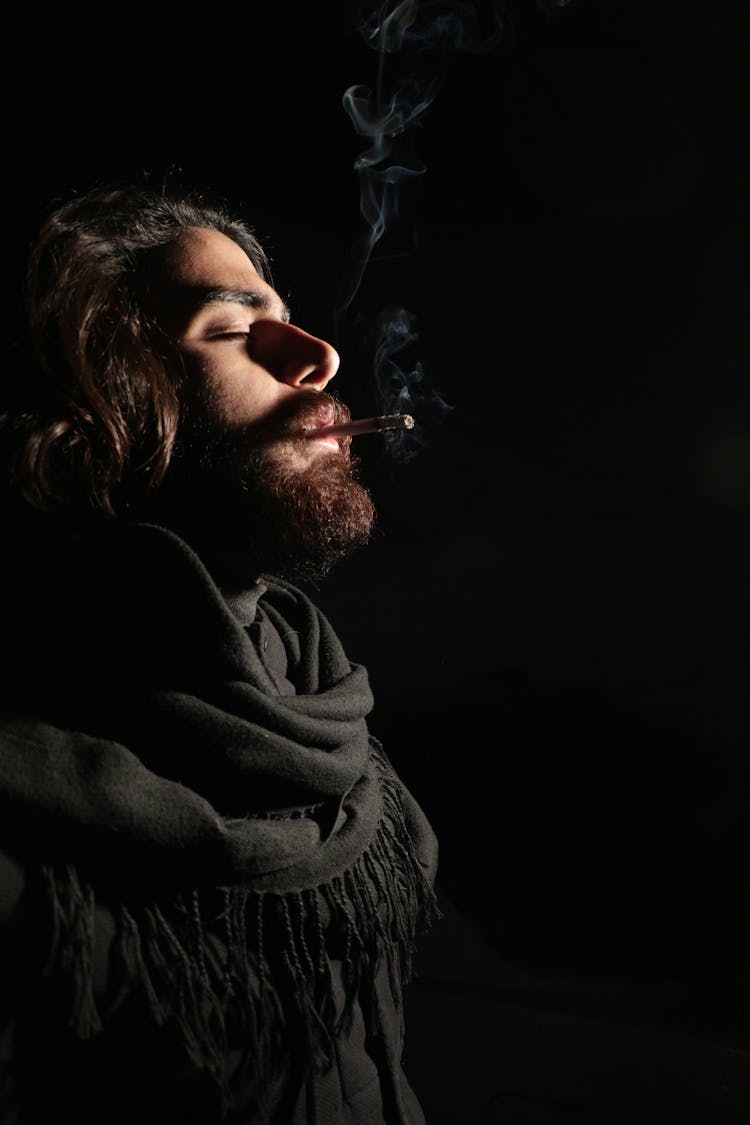 A Man With Black Shawl Smoking Cigarette