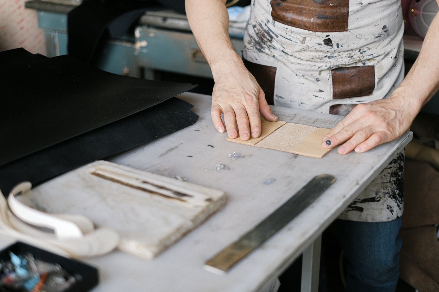 Full-grain leather and tools laid out on a workbench