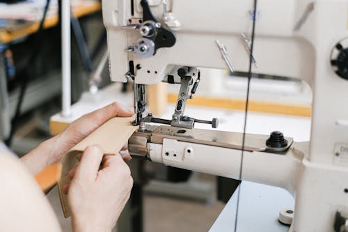 Free A Person Sewing Using Industrial Sewing Machine Stock Photo