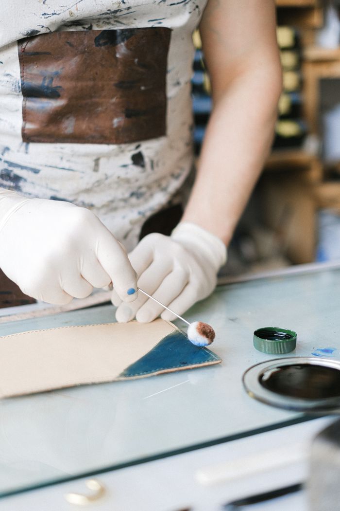 Application d'une teinture sur du cuir par un artisan