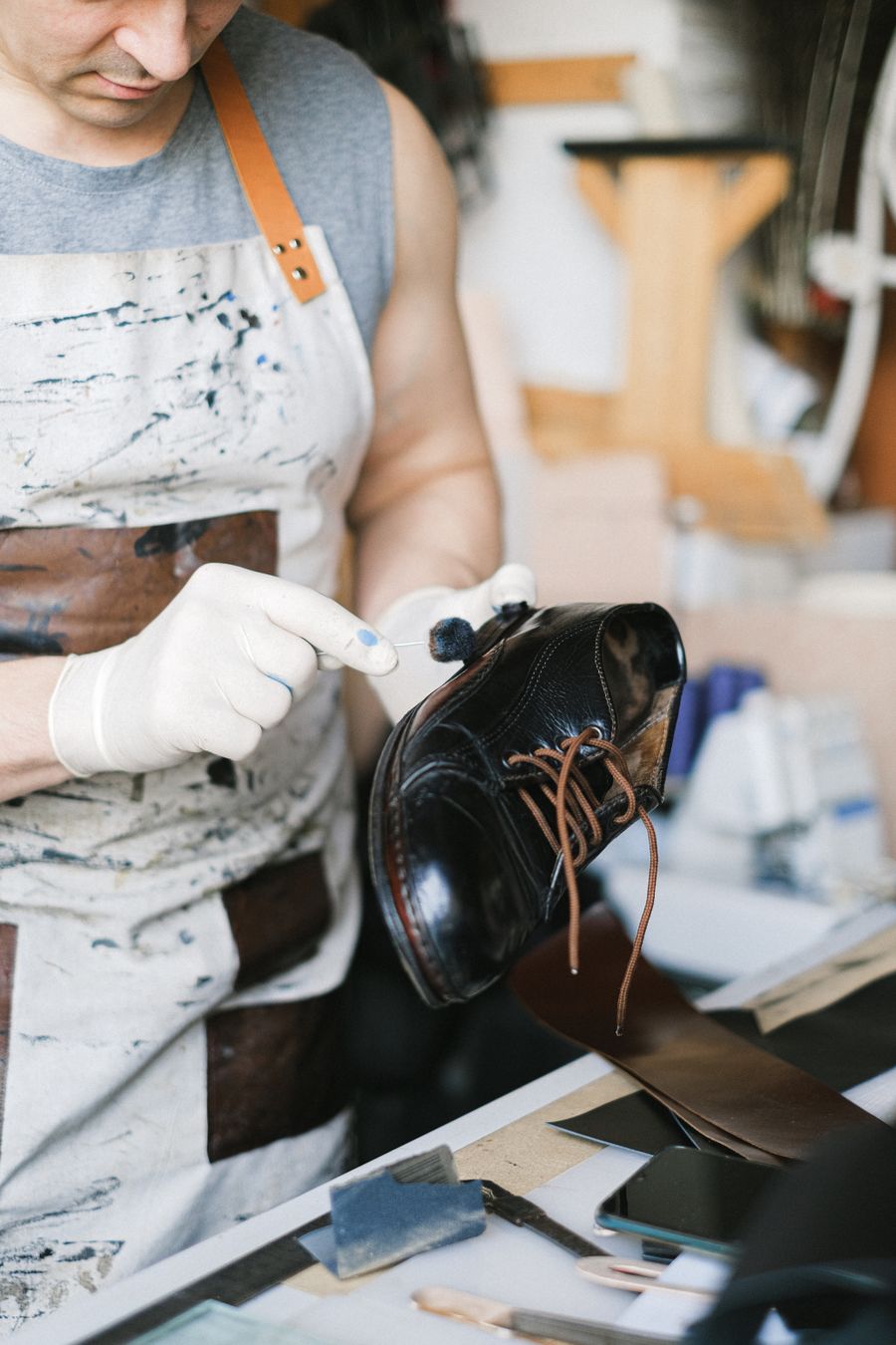 A finished shoe being polished at the bench