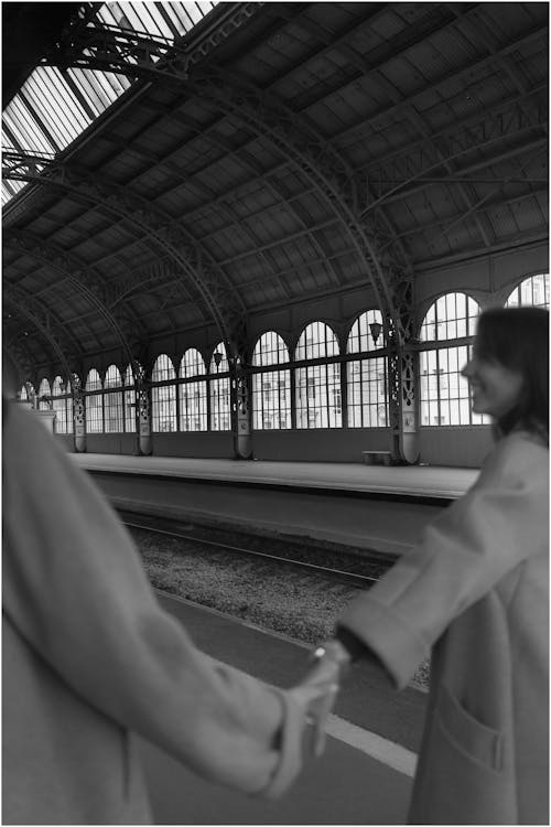 Unrecognizable women holding hands on railway station