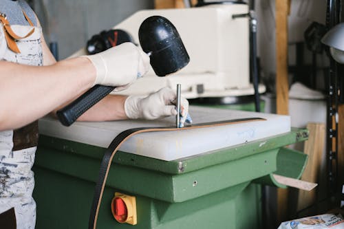 Person in White Gloves Holding a Hammer